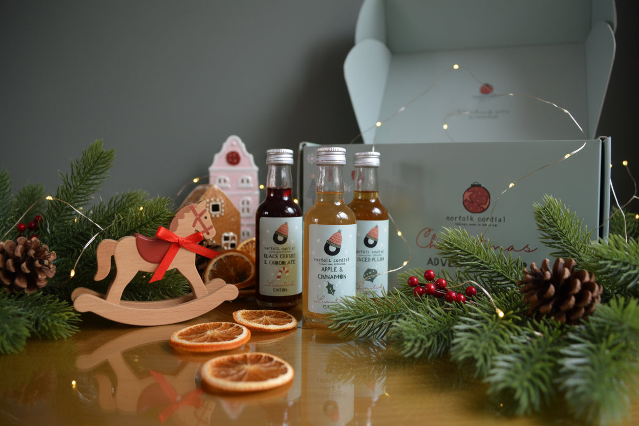 3 miniature cordial bottles sitting infront of advent calendar box