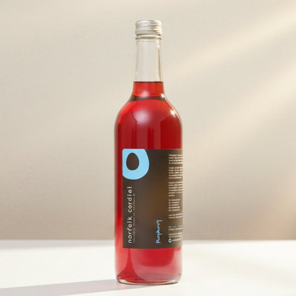 Norfolk Cordial Raspberry 750ml bottle on a warm neutral background