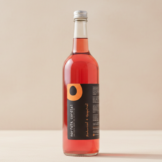 Norfolk Cordial Redcurrant & Grapefruit 750ml bottle on a warm neutral background